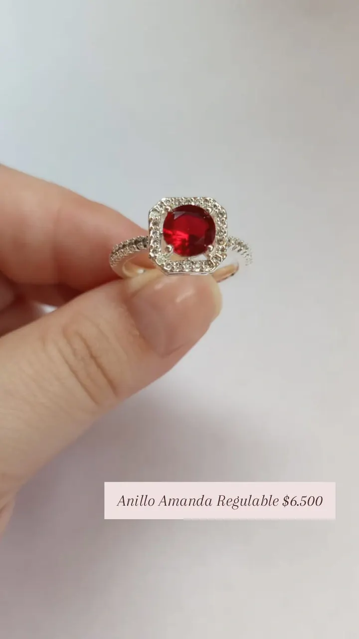 Anillo Amanda Regulable: anillo con piedra roja central y contorno de piedritas, en plateado.