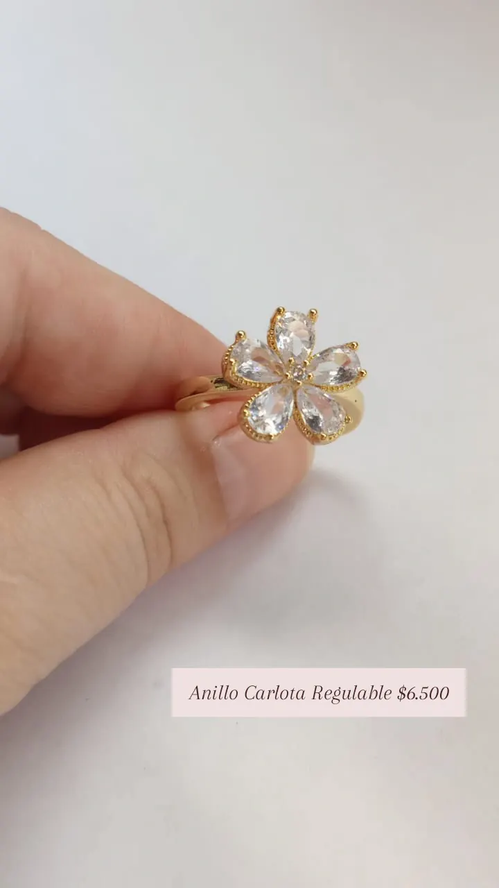 Anillo Carlota Regulable: anillo con flor de cinco pétalos de cristal transparente, en dorado.