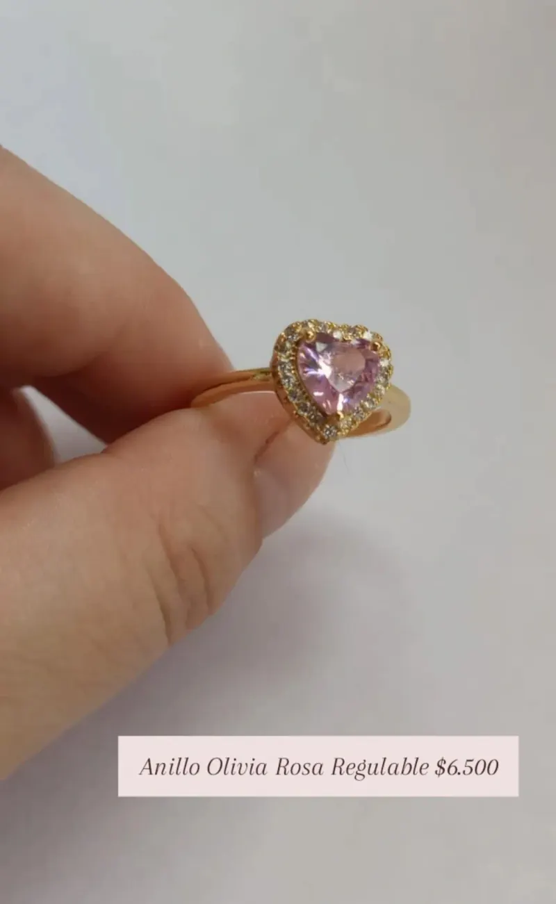 Anillo Olivia Rosa Regulable: anillo dorado con corazón de cristal rosa rodeado de piedritas.
